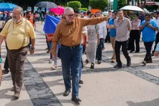 تجمع حشود من الناس في ساحة عامة، مع وجود حاكم ولاية سينالوا Rubén Rocha Moya في المقدمة، حيث يشير بيده.