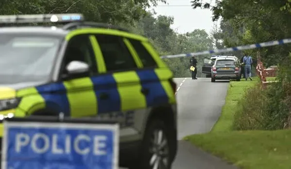 حادث إطلاق نار في منطقة ريفية بأيرلندا الشمالية، مع وجود سيارات الشرطة وأفراد من الطوارئ في موقع الحادث.