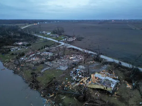 مشهد جوي يظهر الأضرار الواسعة التي خلفتها الأعاصير في إلينوي، حيث دُمرت منازل وأشجار، مع بقايا حطام متناثرة على الأرض.