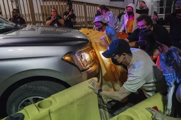 متظاهرون يحاولون منع سيارة من المرور أمام مركز احتجاز في نيوارك، خلال احتجاجات ضد ظروف الاحتجاز وسوء المعاملة.