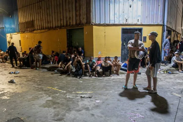 مهاجرون يجلسون داخل مبنى مهجور في سبتة الإسبانية بعد تدفق نحو 60,000 مهاجر من المغرب خلال 24 ساعة في أزمة حدودية حادة.