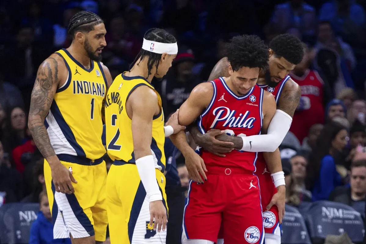 إصابة جاريد ماكين لاعب فيلادلفيا 76ers أثناء مباراة، حيث يساعده زملاؤه بعد تعرضه لإصابة في الركبة.