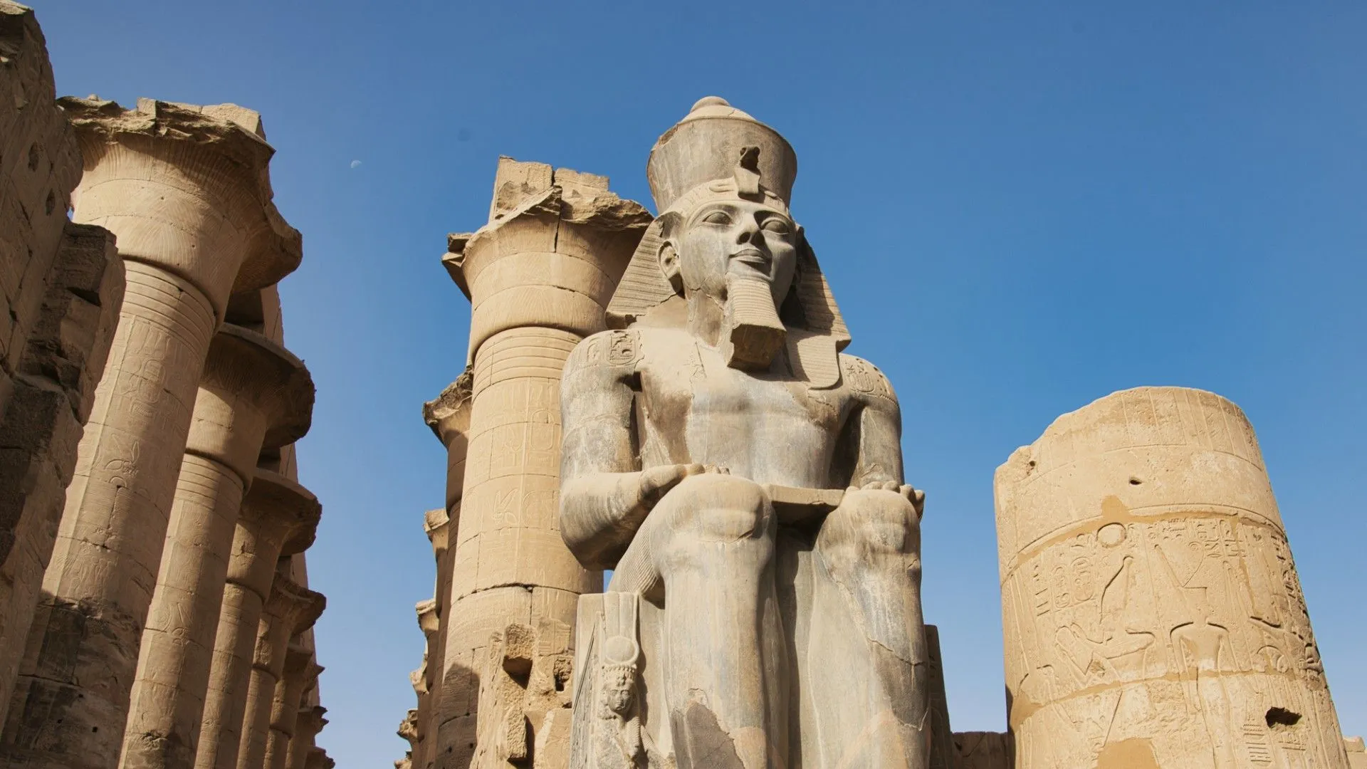 تمثال فرعوني ضخم في معبد الكرنك بالأقصر تحت سماء صافية، موقع رئيسي لمشاهدة كسوف الشمس الكلي في 2 أغسطس 2027.