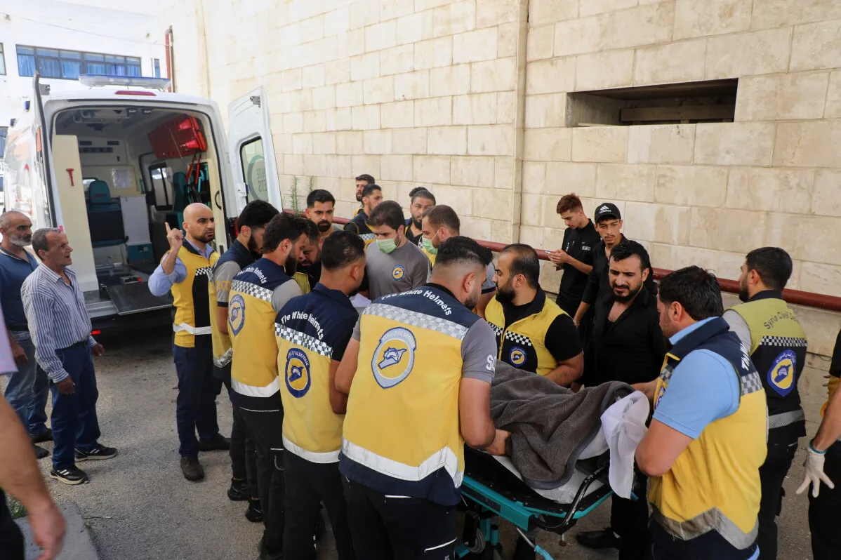 متطوعو الخوذ البيضاء يحملون جثمان محمد غميرة بعد وفاته نتيجة تعذيب في مركز احتجاز بمدينة اللاذقية السورية.