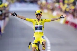 فائز يرتدي القميص الأصفر يحتفل بفوزه في سباق الدراجات، مع جمهور متحمس في الخلفية، ضمن طواف فرنسا للسيدات 2027.