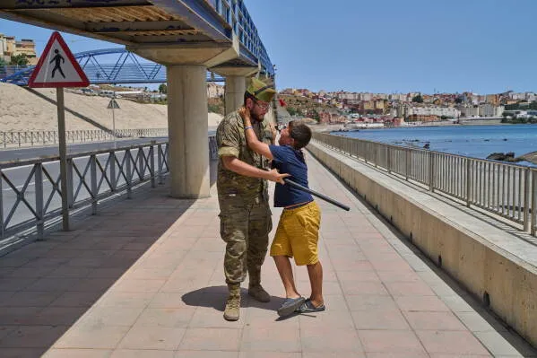طفل يحتضن جنديًا عند الحدود بين المغرب وإسبانيا، في سياق موجة العبور الكبرى نحو سبتة وتأثيراتها الإنسانية والأمنية.