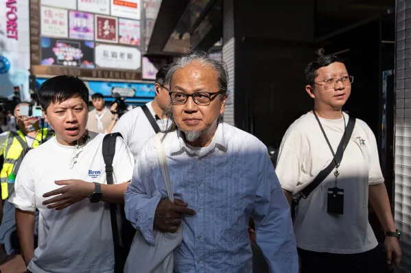 فنّان الأداء Sanmu Chen يتجول في حيّ Causeway Bay في هونغ كونغ، محاطًا بالشرطة ومؤيدين، بعد محاولته إحياء ذكرى أحداث Tiananmen.
