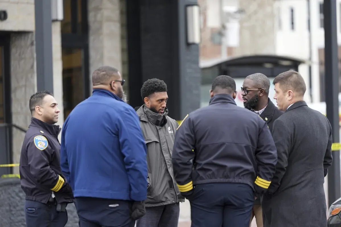 اجتماع لعدد من ضباط الشرطة والموظفين حول حادثة إطلاق نار في محكمة بالتيمور، حيث يتناقشون حول إجراءات الحادث وسلامة الموقع.