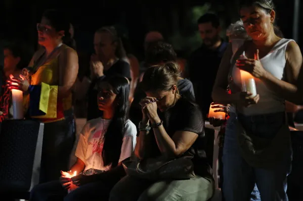 نساء ورجال يحملون شموعاً في وقفة تأملية حداداً على ضحايا زلزال تشوكو الكولومبية المدمر.