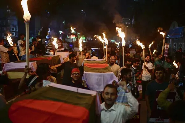 تظاهر حشد من الناس في شوارع دكا حاملين مشاعل ولفائف تحمل علم بنغلاديش، تعبيرًا عن مطالبهم السياسية بعد أحداث العنف الأخيرة.
