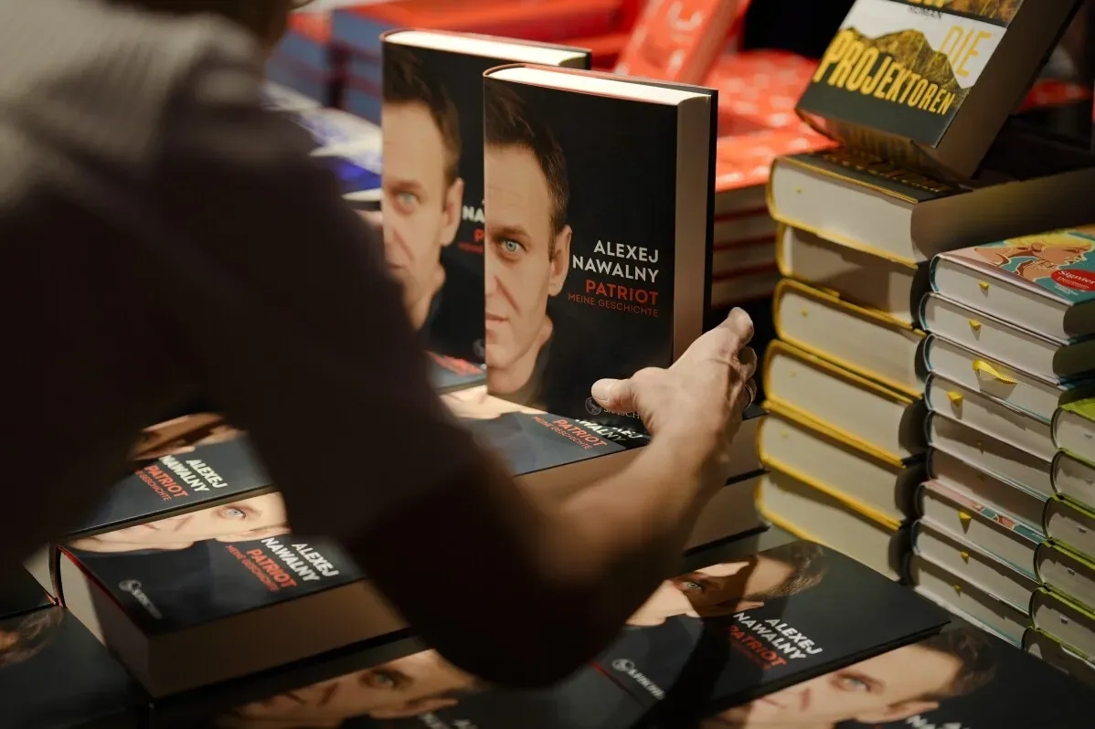 كتب أليكسي نافالني "باتريوت" تعرض قصة زعيم المعارضة الروسي، مع التركيز على محاربة الفساد. الكتاب يظهر على طاولة مغطاة بالكتب.