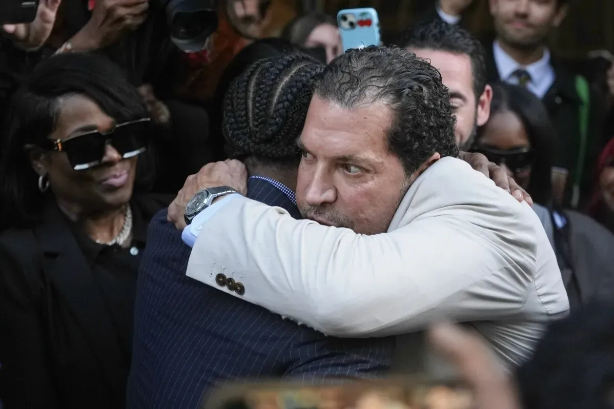 أيساب روكي يحتضن محاميه بعد تبرئته من التهم الجنائية، وسط حشد من المعجبين والمصورين في لوس أنجلوس.
