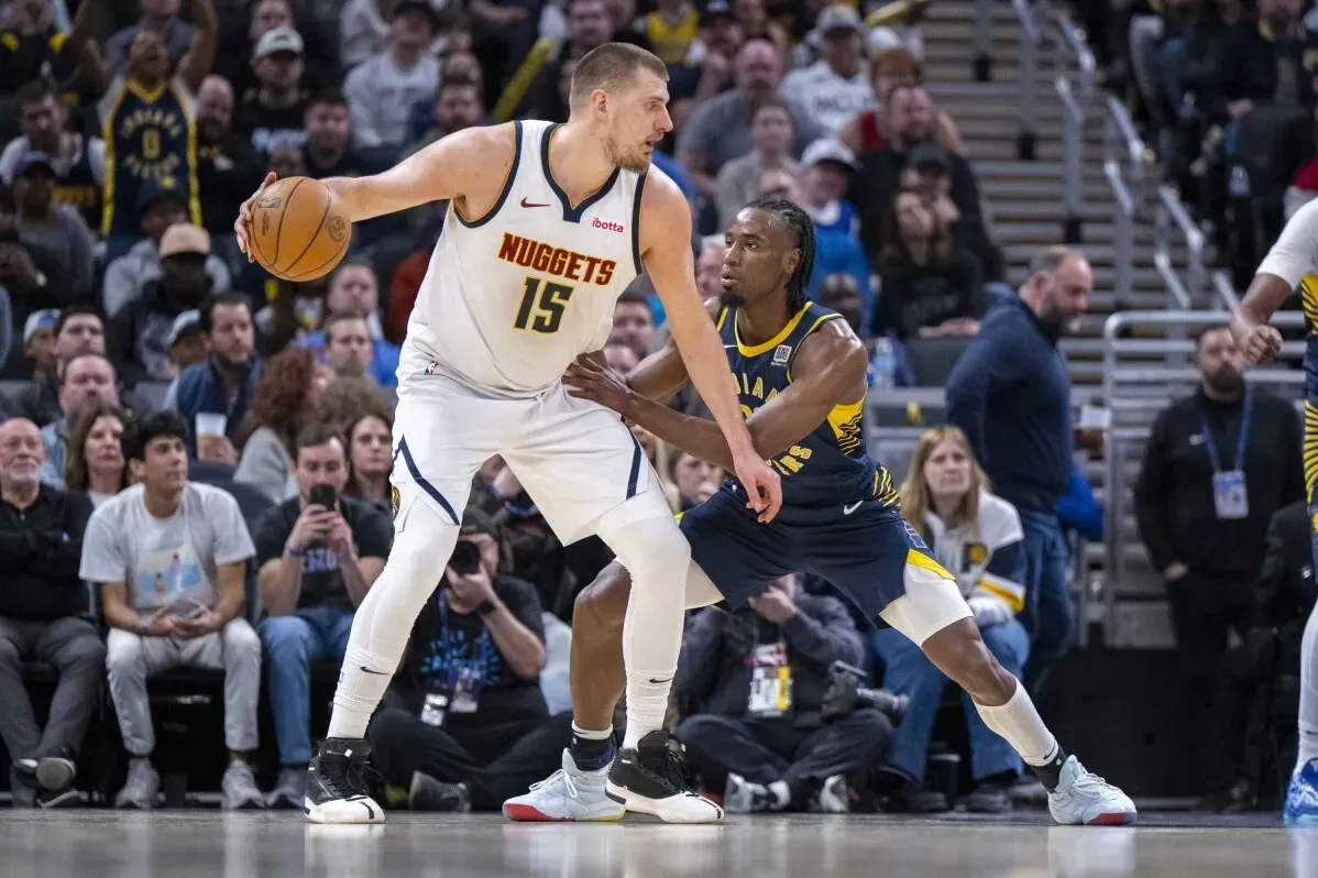 نيكولا جوكيتش يتلاعب بالكرة بينما يدافع عنه لاعب إنديانا، في مباراة بين دنفر ناجتس وإنديانا بيسرز.
