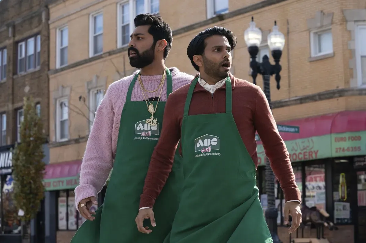 شقيقان أمريكيان من أصل باكستاني يرتديان مآزر في متجر، يعبران عن دهشة أو قلق في مشهد من مسلسل "ديلي بويز" الكوميدي.