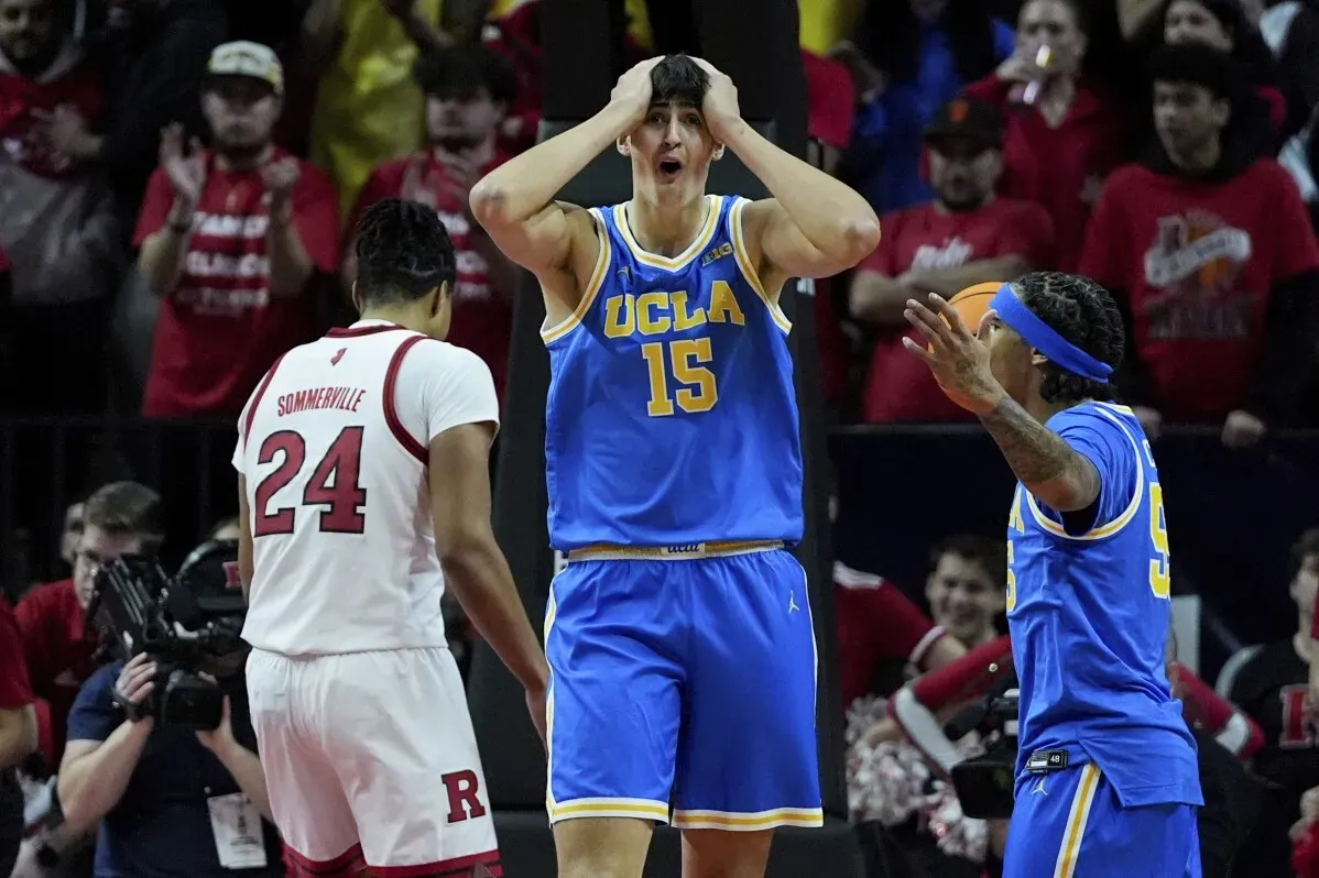 احتفال لاعب من فريق UCLA بعد نقطة حاسمة في مباراة كرة السلة ضد روتجرز، وسط جمهور متحمس.