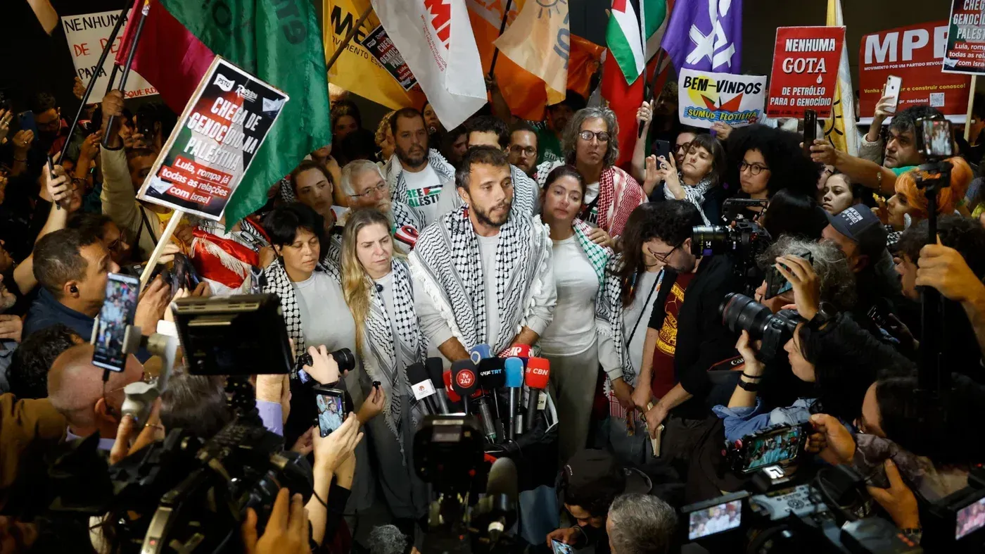 تجمع حشد من النشطاء في حدث لدعم أسطول "صمود" العالمي للمساعدات، مع لافتات تعبر عن التضامن مع فلسطين.