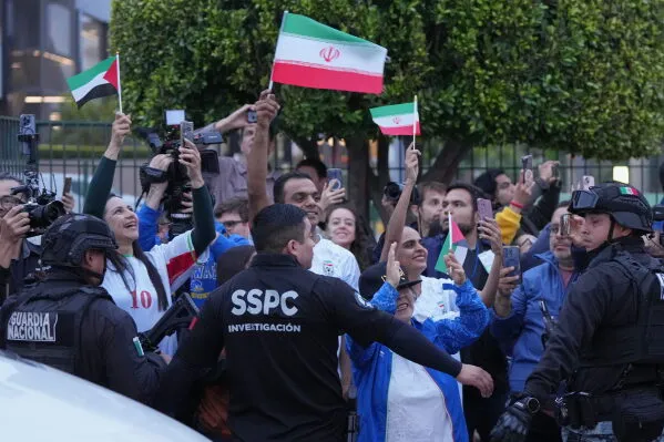 محتفلون يحملون أعلام إيران وسط تواجد أمني، تعبيراً عن دعمهم للمنتخب الإيراني قبل انطلاق كأس العالم.