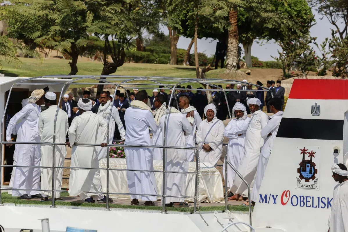 مراسم جنازة الأمير كريم الآغا خان الرابع في أسوان، حيث يرتدي المشاركون ملابس بيضاء ويحيطون بجثمانه خلال النقل في نهر النيل.