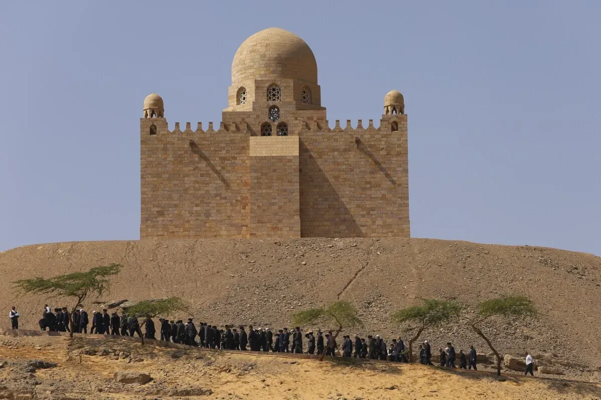 مشيعون إسماعيليون يرتدون ملابس سوداء يتجهون نحو ضريح الآغا خان في أسوان، مصر، خلال مراسم دفنه.