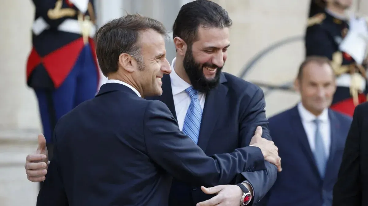لقاء بين الرئيس الفرنسي إيمانويل ماكرون ونائب الرئيس السوري أحمد الشرع في باريس، حيث يتبادلان التحيات وسط أجواء رسمية.