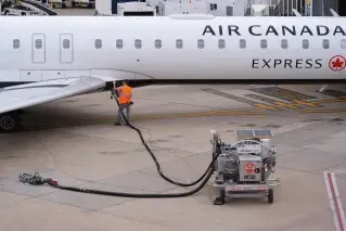 تظهر الصورة طائرة تابعة لشركة Air Canada أثناء عملية تزويدها بالوقود في المطار، مما يعكس تأثير أزمة وقود الطائرات على الرحلات.