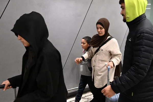 مجموعة من النساء والأطفال الأستراليين تصل إلى مطار ملبورن بعد عودتهم من مخيمات احتجاز في سوريا، وسط إجراءات أمنية مشددة.