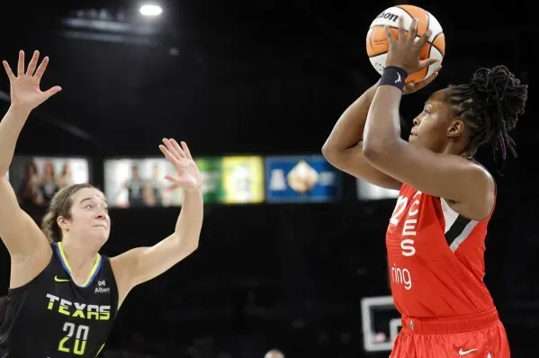 آجا ويلسون تسدد كرة سلة بينما تحاول لاعبة دالاس، تشيلسي جراي، الدفاع عنها في مباراة مثيرة ضمن دوري WNBA.