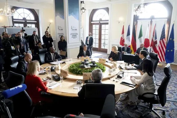 اجتماع وزراء خارجية مجموعة السبع في لا مالباي، كيبيك، حيث يناقشون قضايا دولية مهمة، مع وجود أعلام الدول المشاركة في الخلفية.