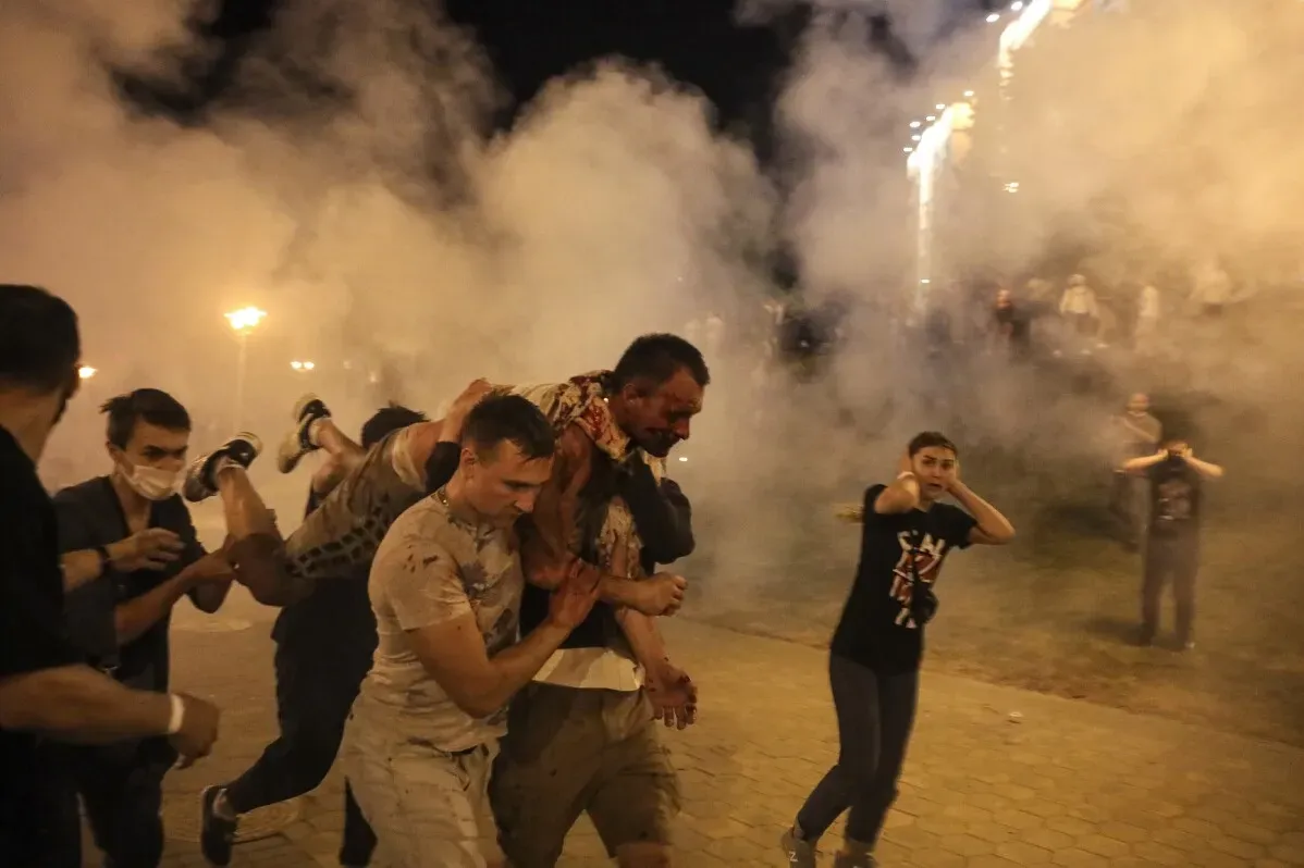 شخصيات ملقاة في الشارع تحت سحابة دخان أثناء احتجاجات ضد الحكومة في بيلاروسيا، تظهر مشاهد من القمع والعنف ضد المتظاهرين.