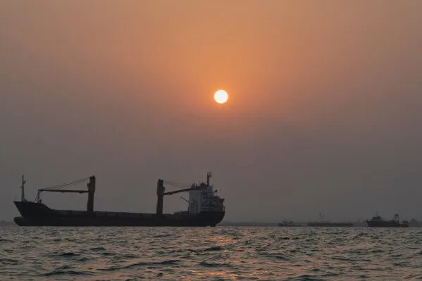 سفينة شحن في ميناء بندر عباس عند غروب الشمس، تعكس ركود النشاط البحري بسبب الحصار الأمريكي وتأثيره على الاقتصاد المحلي.