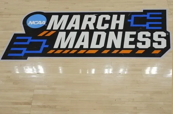 شعار بطولة NCAA "مارس المجنون" على أرضية الملعب، مع التركيز على التصميم الجريء والألوان الزاهية.
