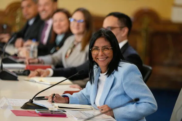 تظهر الصورة Delcy Rodríguez، الرئيسة الفنزويلية بالإنابة، مبتسمة أثناء اجتماع رسمي مع مسؤولين آخرين، مما يعكس تحسّن العلاقات بين فنزويلا والولايات المتحدة.