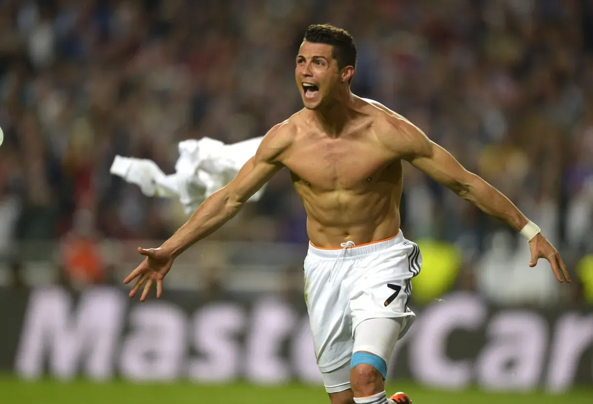 رونالدو يحتفل بتسجيل هدف مع ريال مدريد، عارياً من الجزء العلوي، معبراً عن فرحته في مباراة حماسية.