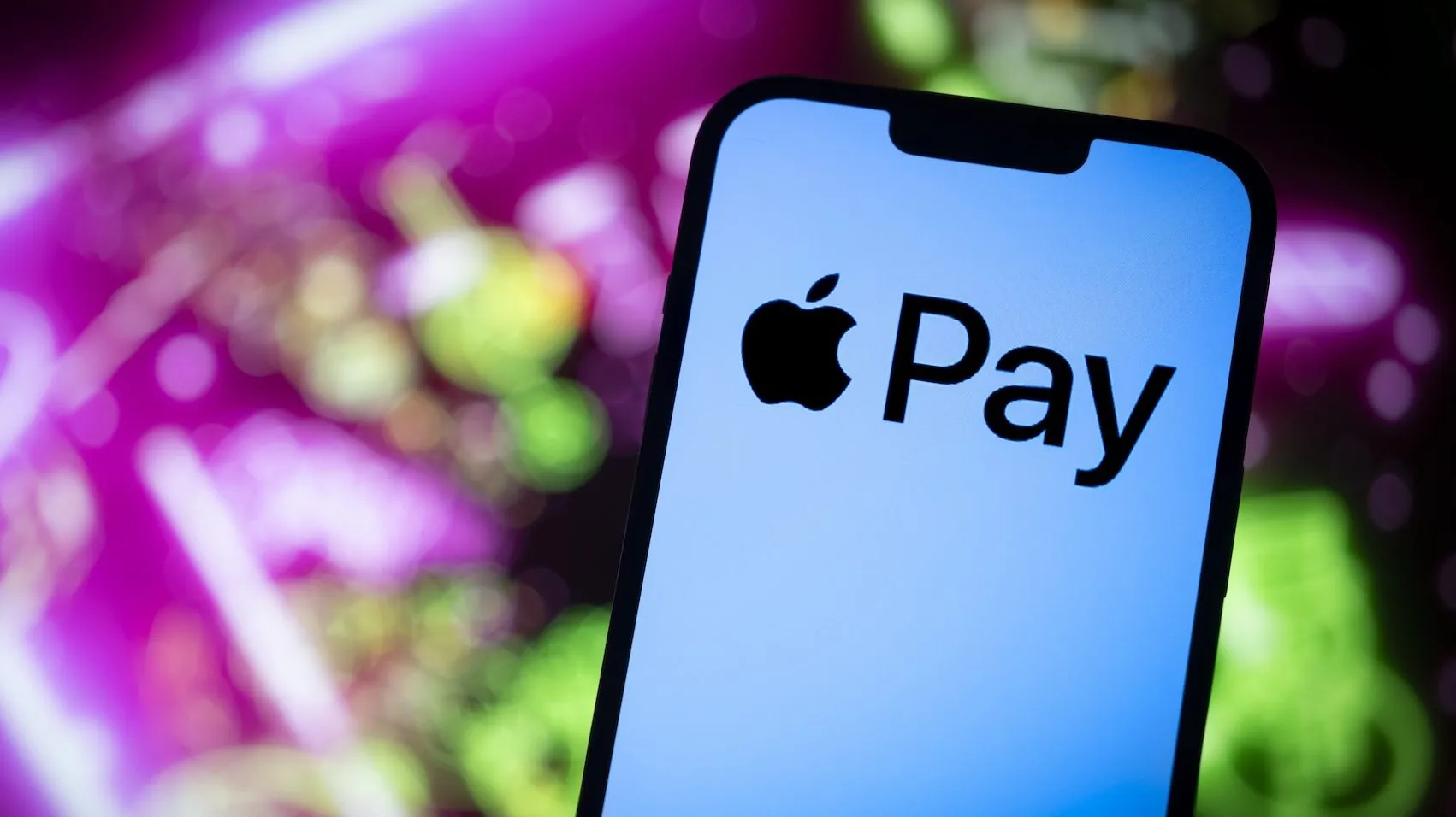 شعار Apple Pay على شاشة آيفون مع خلفية ملونة، يرمز لإطلاق خدمة الدفع الرقمية في الهند بشراكة مع Axis Bank.