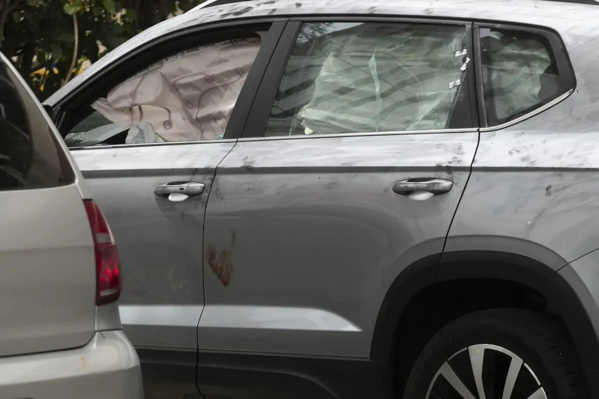 سيارة فضية تحمل آثار طلقات نارية، مع وجود وسائد هوائية منفتحة، تشير إلى حادث مأساوي تعرض له سائح أرجنتيني في ريو دي جانيرو.