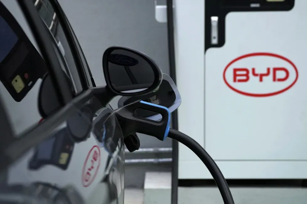 سيارة كهربائية من طراز BYD متصلة بمحطة شحن، تعكس نمو سوق السيارات الكهربائية في البرازيل وتحديات الشركة في كاماكاري.