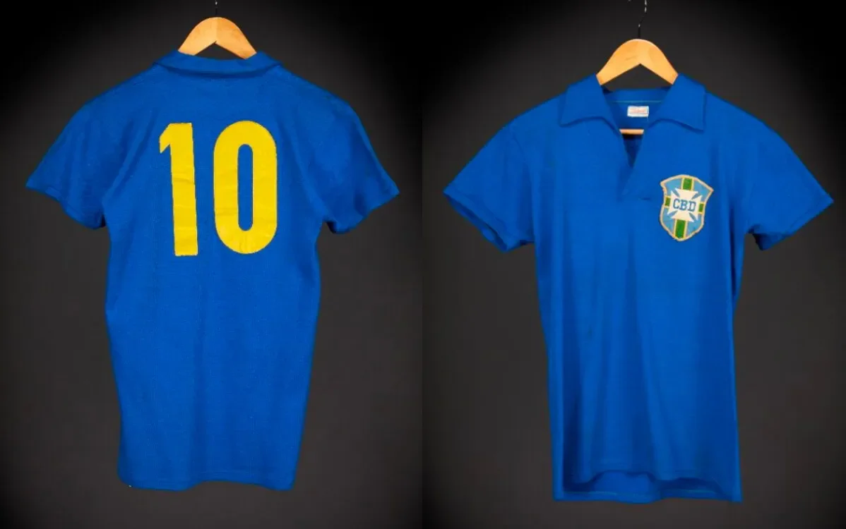 قميص Pelé رقم 10 من نهائي كأس العالم 1958، بلون أزرق وشعار منتخب البرازيل، يُعرض للبيع في مزاد Sotheby's، مما يعكس إرثه التاريخي.