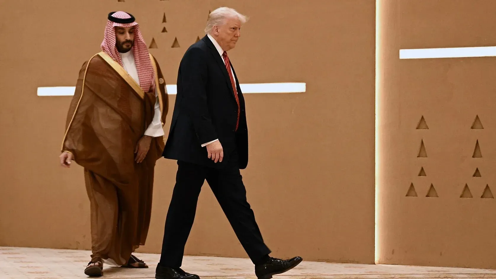 ترامب وولي العهد السعودي محمد بن سلمان يسيران معًا في حدث رسمي، يعكسان العلاقات السياسية والاقتصادية بين الولايات المتحدة والخليج.