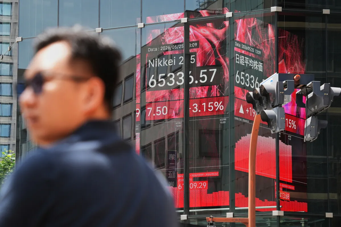 شخص يقف أمام شاشة تعرض بيانات سوق الأسهم اليابانية، مع تراجع مؤشر Nikkei 225 بنسبة 3.15% إلى 65336.57 نقطة.