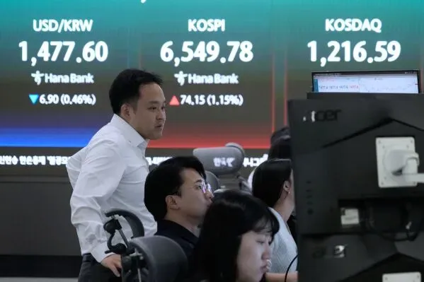 ارتفاع مؤشر Kospi في سوق الأسهم الكورية الجنوبية مع تفاعل المتداولين في خلفية شاشة تعرض أسعار العملات والأسهم.