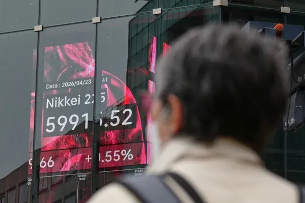 شخص يقف أمام شاشة تعرض بيانات مؤشر Nikkei 225 الياباني، مع تسجيل ارتفاع بنسبة 1% عند 5991.52 نقطة.