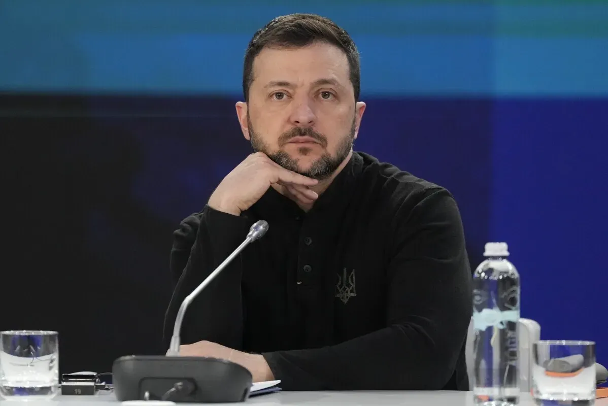 الرئيس الأوكراني فولوديمير زيلينسكي يجلس خلال مؤتمر صحفي، مع التركيز على التحديات الأمنية والاقتصادية لأوكرانيا.