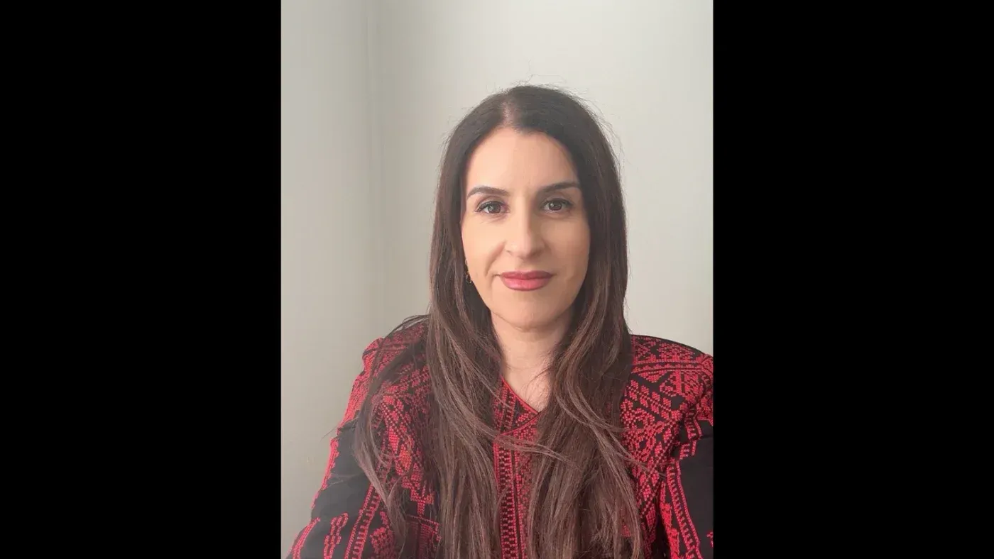 صورة لرندة عبد الفتاح، كاتبة فلسطينية ترتدي ثوبًا تقليديًا، تعبر عن قضايا ثقافية وسياسية في ظل إلغاء ظهورها في مهرجان أديلايد.