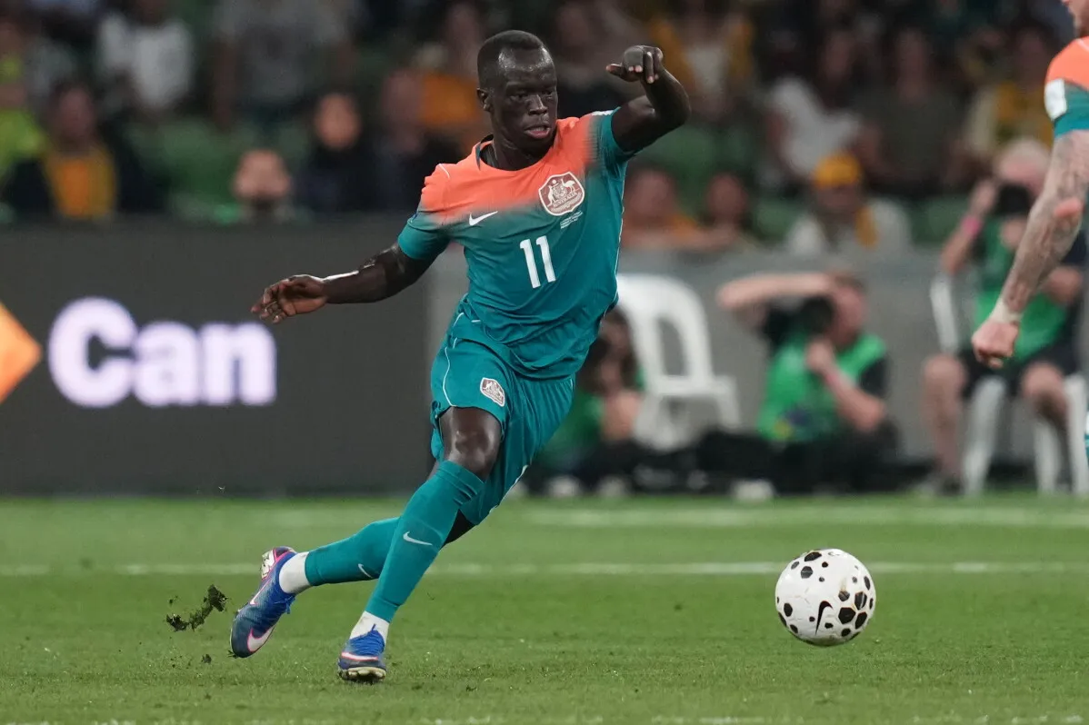 مابيل، لاعب المنتخب الأسترالي، يركض بالكرة خلال مباراة في كأس العالم، معبراً عن شغفه وإرادته في تحقيق النجاح رغم التحديات.