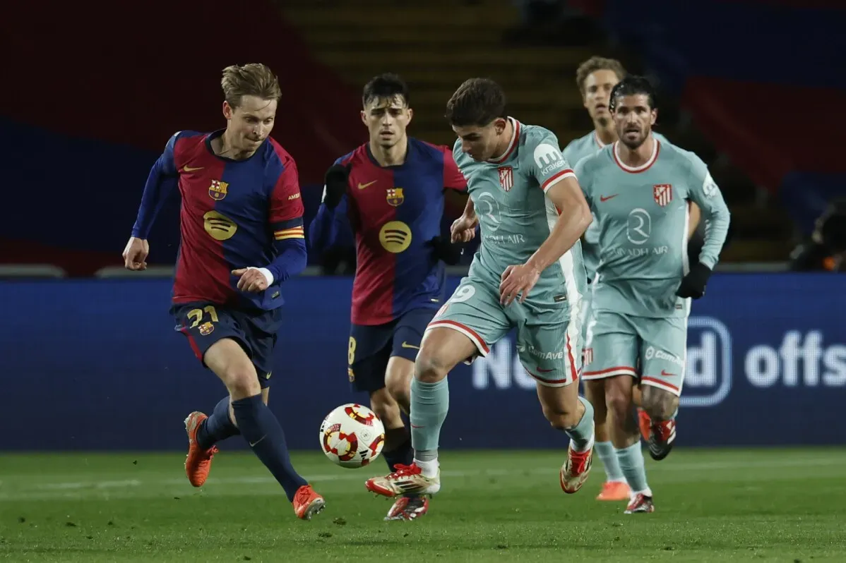 لاعبو برشلونة وأتلتيكو مدريد يتنافسون على الكرة خلال مباراة مثيرة في نصف نهائي كأس الملك، حيث انتهت بالتعادل 4-4.