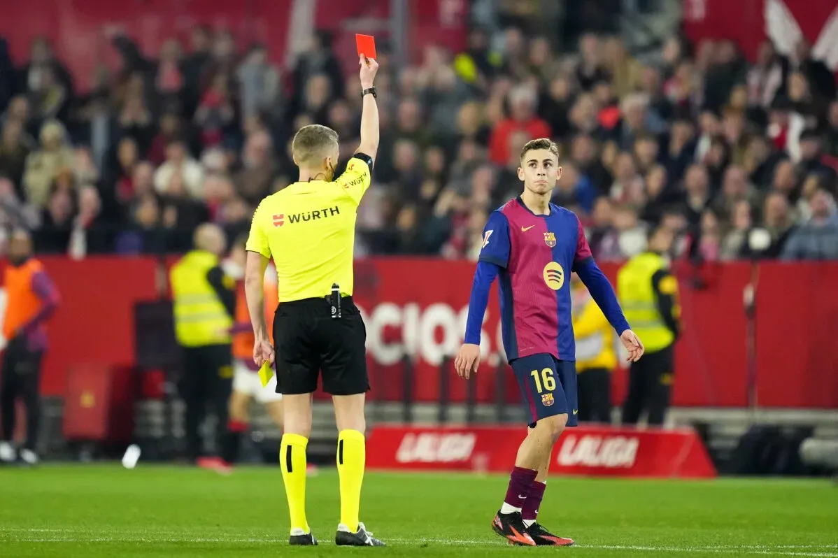 لاعب برشلونة في حالة من الإحباط بعد تلقيه بطاقة حمراء خلال مباراة ضد إشبيلية، مما أثر على مجريات اللقاء.