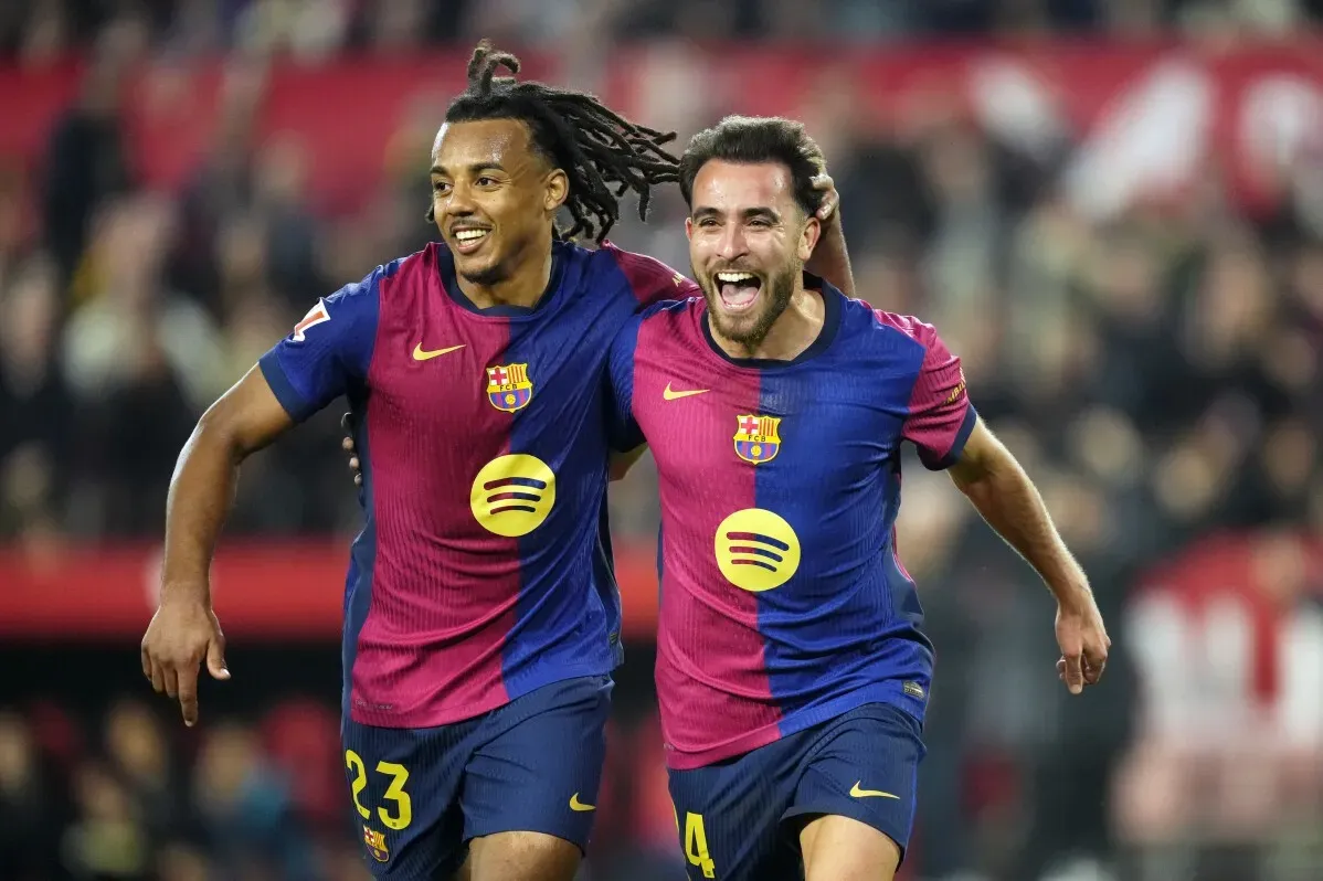 لاعبو برشلونة يحتفلون بتسجيل الأهداف خلال مباراة ضد إشبيلية، مما يعزز المنافسة على لقب الدوري الإسباني.