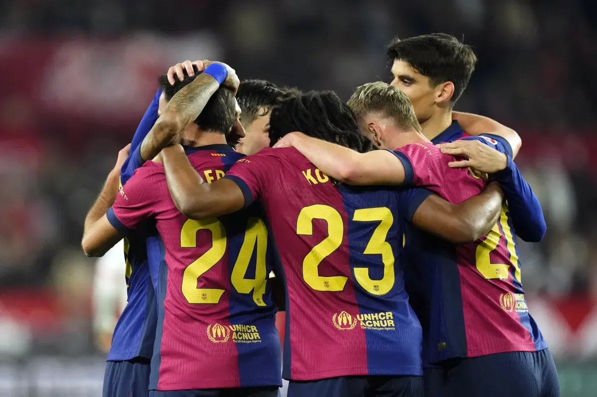 لاعبو برشلونة يحتفلون بعد تسجيل الأهداف في مباراة ضد إشبيلية، حيث فاز الفريق 4-1 ويقترب من صدارة الدوري الإسباني.