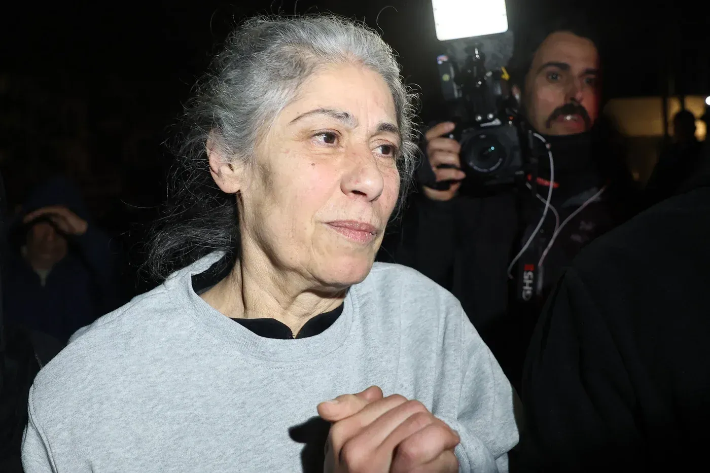 خلت امرأة فلسطينية من السجن، تظهر علامات التعب على وجهها وشعرها الرمادي، بينما تعبر عن مشاعر الفرح بعد الإفراج عنها كجزء من اتفاق وقف إطلاق النار.