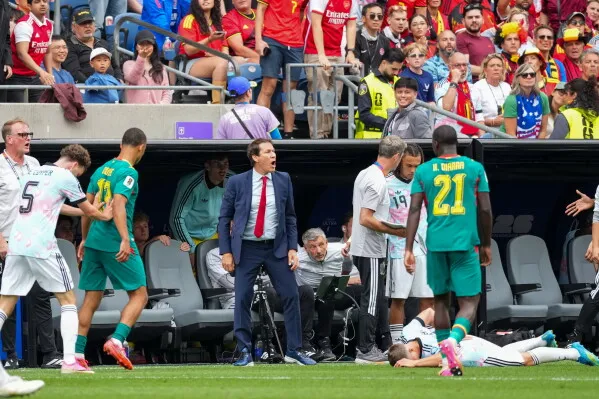 مدرب بلجيكا رودي غارسيا يصرخ على خط الملعب خلال مباراة كأس العالم ضد السنغال، مع لاعبين من الفريقين وحضور جماهيري في الخلفية.